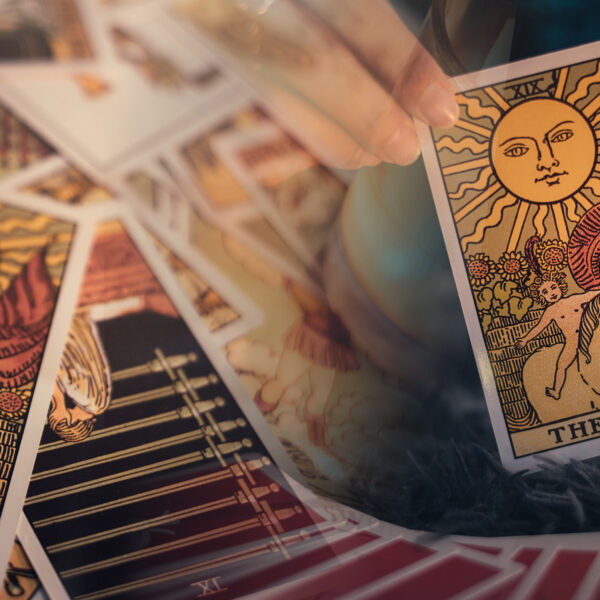 Fortune teller holding THE SUN card and tarot cards. tarot cards and burning candles. Astrologists and forecasting concept. Banner Background.
